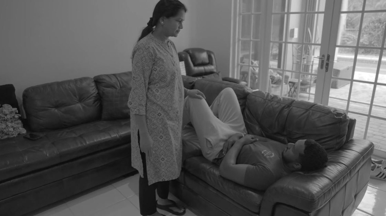 Alfin Jeyaseelan laying on a couch not feeling well.