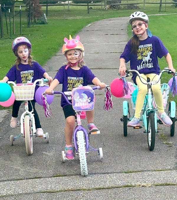 three young girls on bicycles
