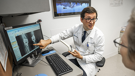 Provider showing images of knee replacement to patient