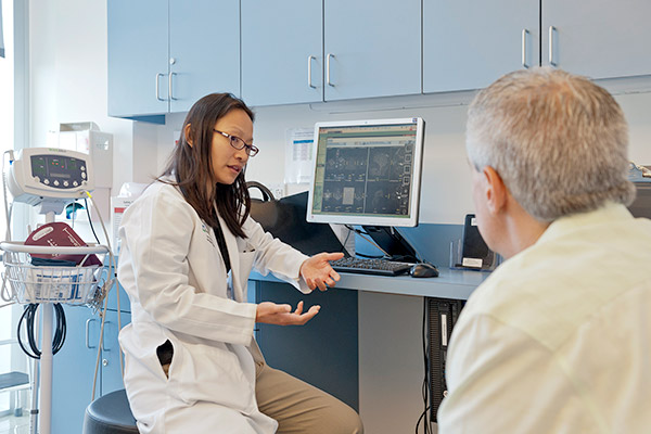 Le Hua, MD speaks with an MS patient.