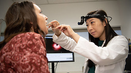 Cleveland Clinic provider looking at patient's mouth and throat